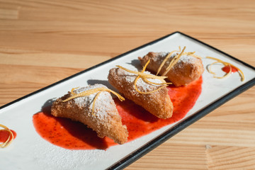 Spanish Leche Frita Dessert, decorated with jam close-up on a plate.
