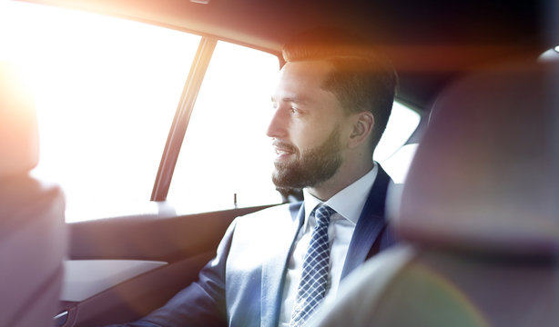 Smiling Business Man Sitting In The Back Seat Of A Car