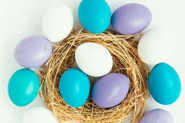colored Easter eggs in nest on wooden background, selective focus image. Happy Easter card 