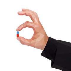 Fototapeta premium Male polygonal arm holds between two fingers a capsule