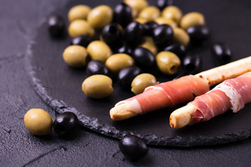 Traditional italian bread sticks grissini with prosciutto ham