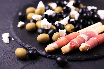 Traditional italian bread sticks grissini with prosciutto ham