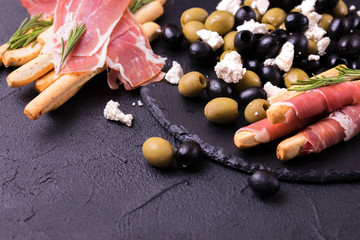 Traditional italian bread sticks grissini with prosciutto ham