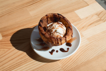 Traditional Mexican dessert churros served with ice cream on white plate on wooden table