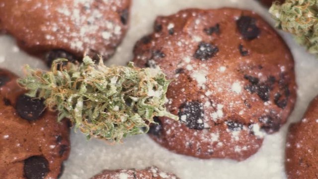 Cookies with CBD cannabis and buds of marijuana on the table. A can of cannabis buds Concept of cooking with cannabis herb. Treatment of medical marijuana for use in food, On a black background