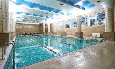 Indoor public swimming pool interior in fitness gym club. healthy concept