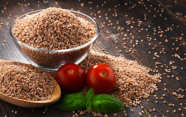 Bowl of uncooked spelt on wooden table