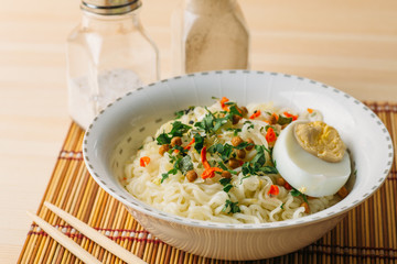 Instant noodles in bowl, Asian fast food on wooden table