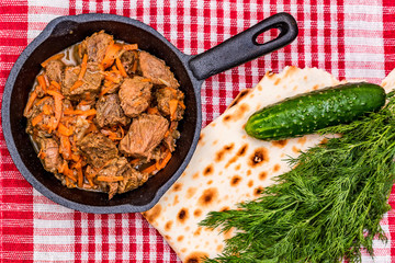 Beef stew in frying pan and vegetables