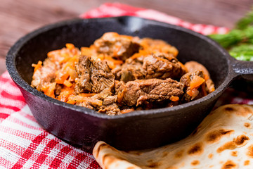 Beef stew in frying pan and vegetables