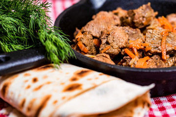 Beef stew in frying pan and vegetables