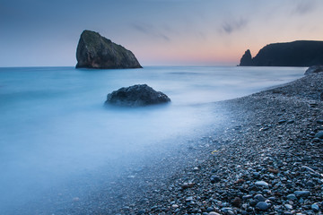 Scenic sunset on a rocky seashore on long exposure