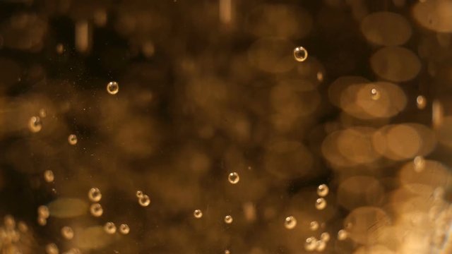 Macro of champagne or sparkling wine with the bubbles or fizz on black background. Concept for party, luxury or luxurious or new years eve celebration