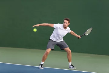 Foto op Plexiglas Professional tennis player athlete man hitting forehand ball on hard court playing tennis match. Sport game fitness lifestyle person living an active summer lifestyle. © Maridav