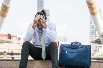 Tired or stressful businessman sitting sadly on the stairs after working