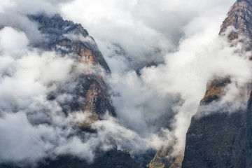 Mountains in low clouds in overcast evening in Nepal. Landscape with beautiful high rocks and...