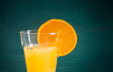 Orangenscheibe am Glas mit Orangensaft mitte