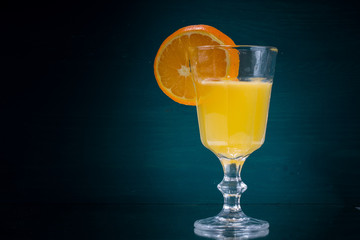 Orangescheibe am Glas mit Orangensaft mitte