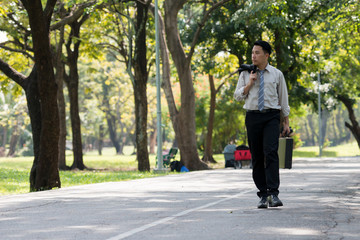 Young Asia businessman showing stress face. He was walking in the Park..