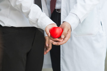 Woman in a business suit shows hands with heart.