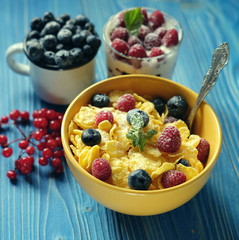 Healthy breakfast. corn flakes with raspberries and blueberries and granola with yogurt and berries.