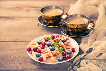 Homemade wafers with berries and coffee on a table. Selective focus. Copy space.