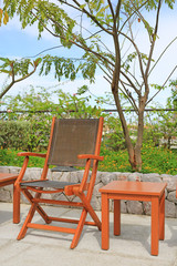 Wooden chairs set beside a pool.

