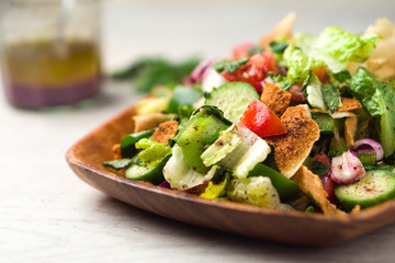 Healthy fattoush salad closeup. The key ingredient in this middle eastern dish is the toasted pita bread which is mixed with healthy vegetables, herbs and a dressing made with lemon and sumac.