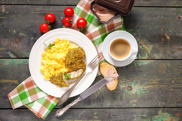 Breakfast - an omelet, chicken fillet in a green breading and coffee on a table. Selective focus. Top view. Copy space.