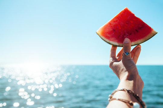 Watermelon Slice In Woman Hand Over Sea