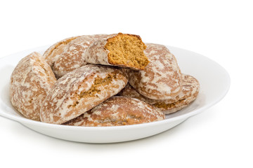 Glazed gingerbreads on the white dish closeup on white background