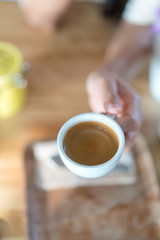 Hot espresso coffee on women hand holder