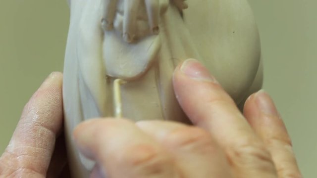Work on completion of a porcelain figurine depicting a naked figure of a girl.