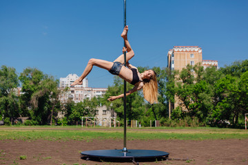 Fit attractive girl dancing near portable pole at summer day © Smile