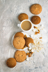 Cup of Coffee with Milk, Cookies, Raisins, Oat Flakes on a light background. Top view