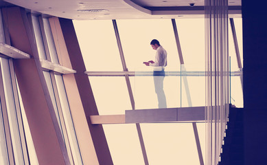 young successful business man in penthouse apartment working on tbalet