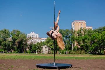 Fit attractive girl dancing near portable pole at summer day © Smile