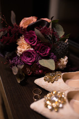 Wedding. Bridal Bouquet in marsala colors and near a beige shoes with shiny stones on them. Wedding shoes with sparkling stones. 