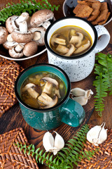 Mushroom soup with croutons in ceramic mug on rustic wooden background - healthy organic homemade vegetarian vegan delicious soup meal lunch food