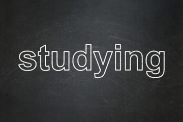 Education concept: text Studying on Black chalkboard background