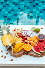 Fototapeta na wymiar Colorful tropical fruit plate by the pool