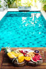 Colorful tropical fruit plate by the pool