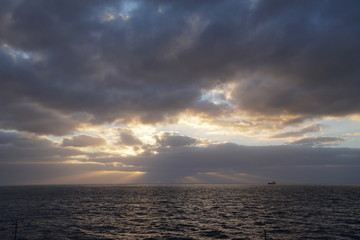 Naklejka premium Morning. The sun in the clouds above the ocean