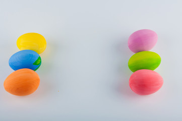 Six colored eggs laying on white background