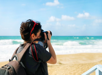 A young girl takes pictures of a beautiful view of the sea