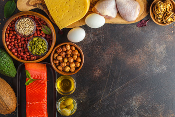 Keto (ketogenic) diet concept. High protein food, food frame background. Vegetables, fish, meat, cheese, nuts on a dark background.