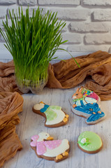 Cute Easter cookies. Bunny, geese and egg laying near green grass on white background