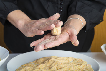 Chef reparando croquetas para la comida en la mesa de la cocina, cocinar es su trabajo.