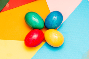Four colored Easter eggs on colorful background