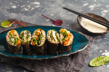 Vegan sushi sandwich onigirazu with tofu and vegetables. Colorful japan sandwich onigirazu with tofu, sweet potato, avocado and tahini. Trend vegan food concept. Top view, copy space.